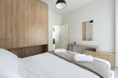 a bedroom with two white beds and a mirror at Lardos Luxury Apartments in Lardos
