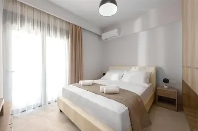 a white bedroom with a large bed with white pillows at Lardos Luxury Apartments in Lardos