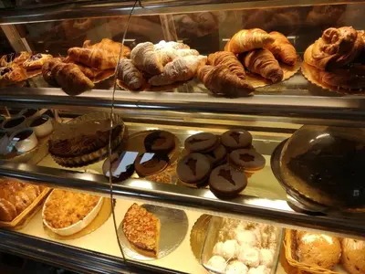 a display case in a bakery filled with lots of pastries at The Grandma House in Ialyssos
