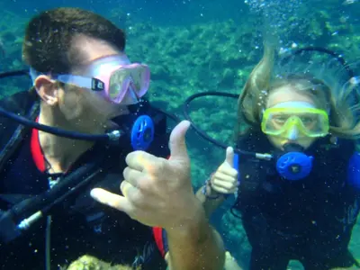 a man and woman giving thumbs up while scuba diving at The Grandma House in Ialyssos