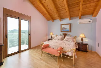 a bedroom with a bed and a large window at Villa Kaloudis in Kolimbia