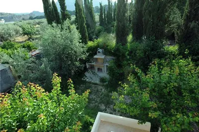 a garden with a bench and trees and bushes at Villa Kaloudis in Kolimbia
