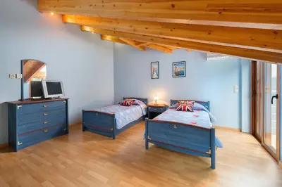 a bedroom with two beds and a desk and a tv at Villa Kaloudis in Kolimbia