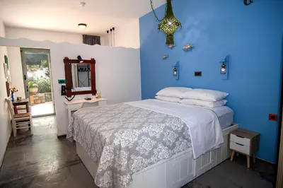 a blue bedroom with a bed and a mirror at Pefkos Eye in Pefki Rhodes