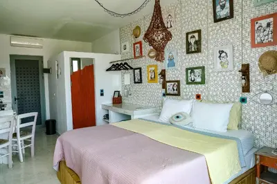a bedroom with a bed and a wall with pictures at Pefkos Eye in Pefki Rhodes