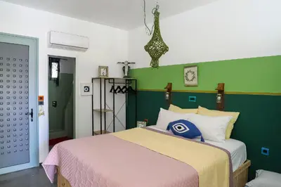 a bedroom with a bed and a green wall at Pefkos Eye in Pefki Rhodes