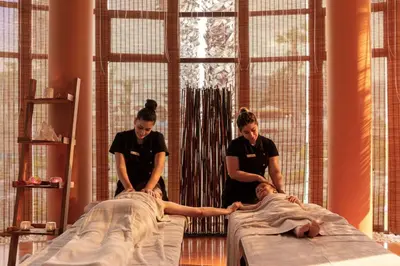 two women helping a man laying on a bed at Atrium Palace Thalasso Spa Resort And Villas in Kalathos