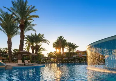 a pool at a resort with palm trees at Atrium Palace Thalasso Spa Resort And Villas in Kalathos