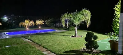 a swimming pool in a yard at night at M&B Luxury House in Theologos