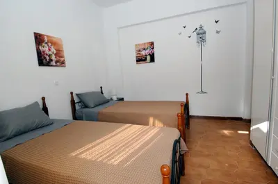 a bedroom with two beds and a lamp on the wall at Salakos Mountain View Home in Sálakos