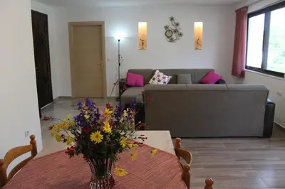 a living room with a table with a vase of flowers at Salakos Mountain View Home in Sálakos