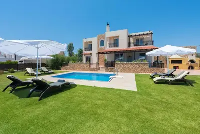 a yard with chairs and a swimming pool and a house at MarySol Luxury Villa in Gennadi
