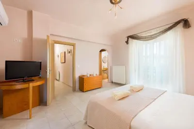 a bedroom with a bed and a flat screen tv at MarySol Luxury Villa in Gennadi