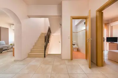 a hallway with a staircase and a living room at MarySol Luxury Villa in Gennadi