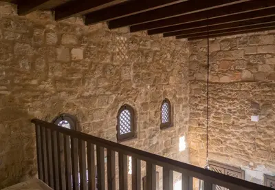 a stone wall with three windows and a staircase at Trinity Boutique Hotel in Rhodes Town