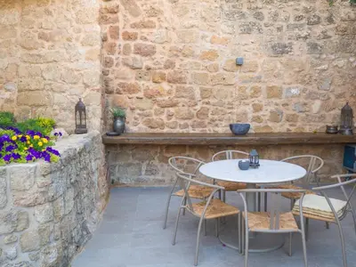 a patio with a table and chairs and a brick wall at Trinity Boutique Hotel in Rhodes Town