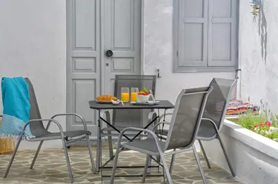 a table and chairs on a patio with a plate of food at Lindos Tholos Villa in Líndos