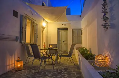 a patio with chairs and a table at night at Lindos Tholos Villa in Líndos