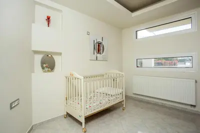 a white crib in a white room with a window at EVA's House in Pastida