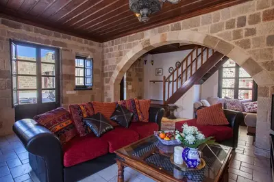 a living room with red couches and a brick wall at Medieval Dreams Villa in Rhodes Town
