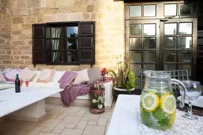 a patio with a couch and a table with a vase at Medieval Dreams Villa in Rhodes Town