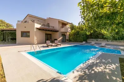 a villa with a swimming pool in front of a house at Villa Leyland in Faliraki