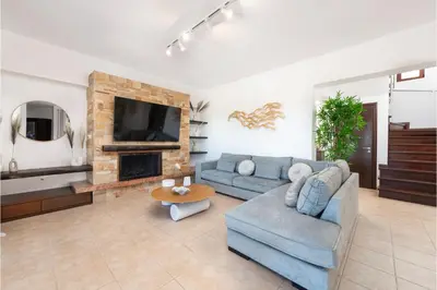 a living room with a blue couch and a fireplace at Villa Leyland in Faliraki