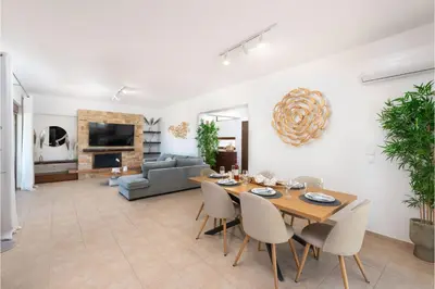 a dining room and living room with a table and chairs at Villa Leyland in Faliraki