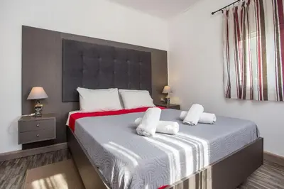 a bedroom with a large bed with two white towels at Filerimos House in Ialyssos