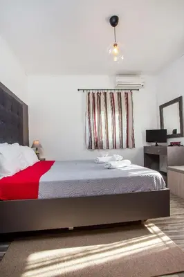 a bedroom with a bed with a red blanket at Filerimos House in Ialyssos