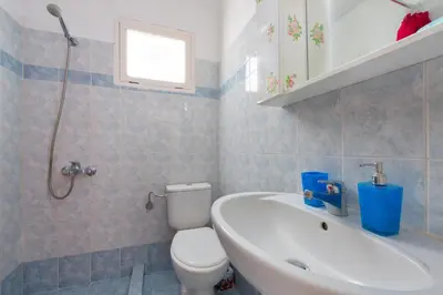 a bathroom with a white toilet and a sink at Filerimos House in Ialyssos