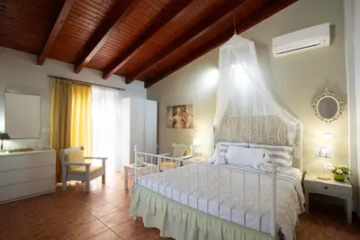 a bedroom with a white bed with a canopy at Green Apartments in Faliraki