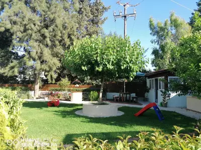a yard with a playground and a tree at Green Apartments in Faliraki