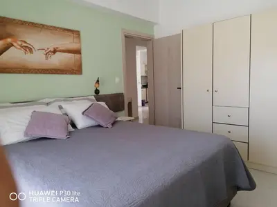 a bedroom with a large bed with purple pillows at Green Apartments in Faliraki