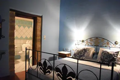 a bedroom with a bed and a bathroom with a toilet at Antifanous Apartments in Rhodes Town