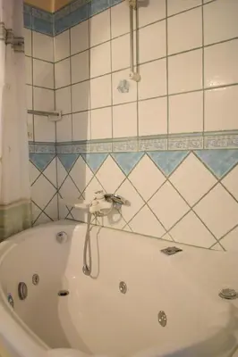 a bath tub with a faucet in a bathroom at Antifanous Apartments in Rhodes Town