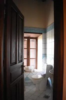 a bathroom with a toilet and a window at Antifanous Apartments in Rhodes Town