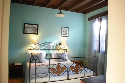 a bedroom with a bed in a blue wall at Antifanous Apartments in Rhodes Town