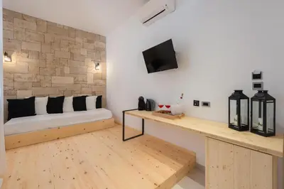 a room with a bed and a tv on a wall at Old Town Senses Boutique Hotel in Rhodes Town