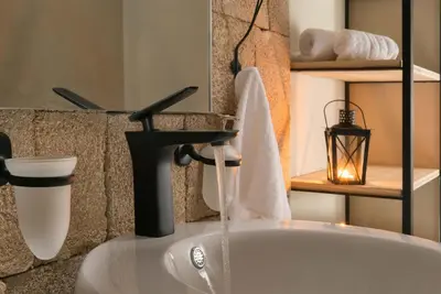 a bathroom with a sink with water coming out of it at Old Town Senses Boutique Hotel in Rhodes Town