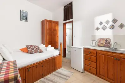 a kitchen with a bed and a sink in a room at Apostolos Rooms in Líndos