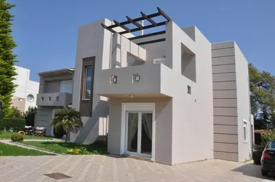 a white house with a driveway at Beautiful house with garden in Rhodes in Ialyssos