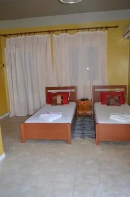 two beds sitting in a room with curtains at 