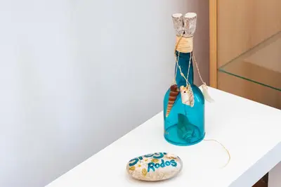 a bottle of rocks on a shelf next to a cookie at Dimitras Luxus House in Archangelos