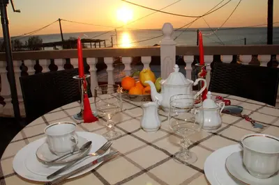 a table with a view of the ocean at sunset at Dimitras Luxus House in Archangelos