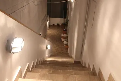a long hallway with stairs with lights on the walls at Dimitras Luxus House in Archangelos