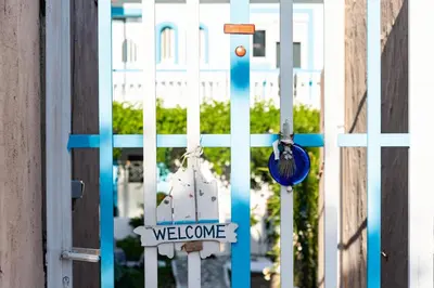 a white gate with a welcome sign on it at Dimitras Luxus House in Archangelos