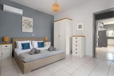 a bedroom with a large bed with blue walls at Villa Bella with Private Pool and Hot Tub in Lardos