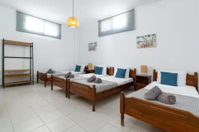 a group of four beds in a room with windows at Villa Bella with Private Pool and Hot Tub in Lardos