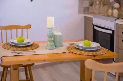 a kitchen table with two plates and candles on it at Lindos SeaView Apartment in Líndos